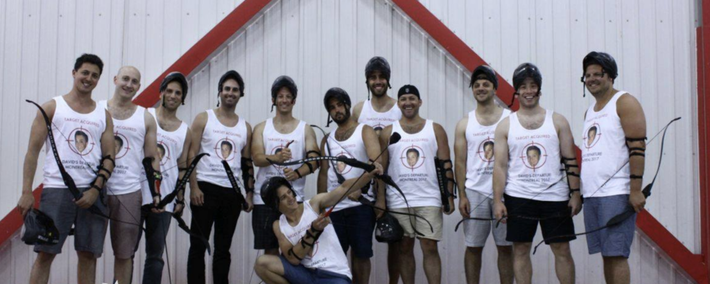  A group of friends get together at an archery range for a bachelor party and wear their matching custom tanks. 