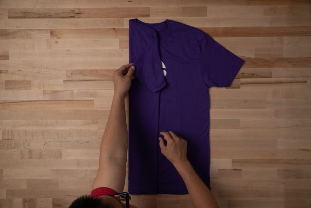 Fold in the left side of the shirt to start rolling it
