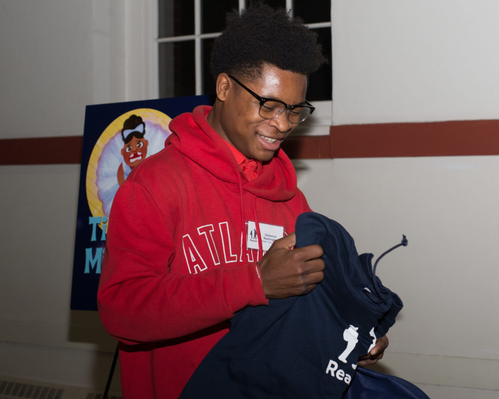 Young tutor receiving a custom hoodie after getting promoted