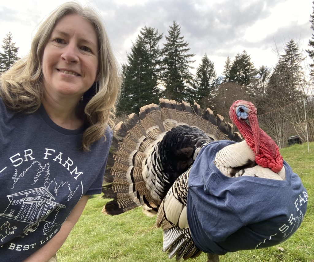 Stacy and her turkey Ringo both wearing custom 5R Farm shirts. The shirts are Allmade Tri-Blend T-shirt and District Women's Tri-Blend V-Neck T-shirt.
