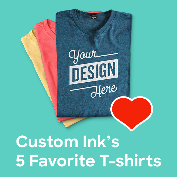 A stack of custom t-shirts. The top one says "Your design here" and has a heart on top of it. Text below reads "Custom Ink's 5 Favorite T-shirts."