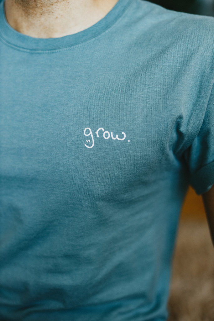 Close up on a t-shirt featuring Tyler Conroy's "grow." logo as designed by his dad.