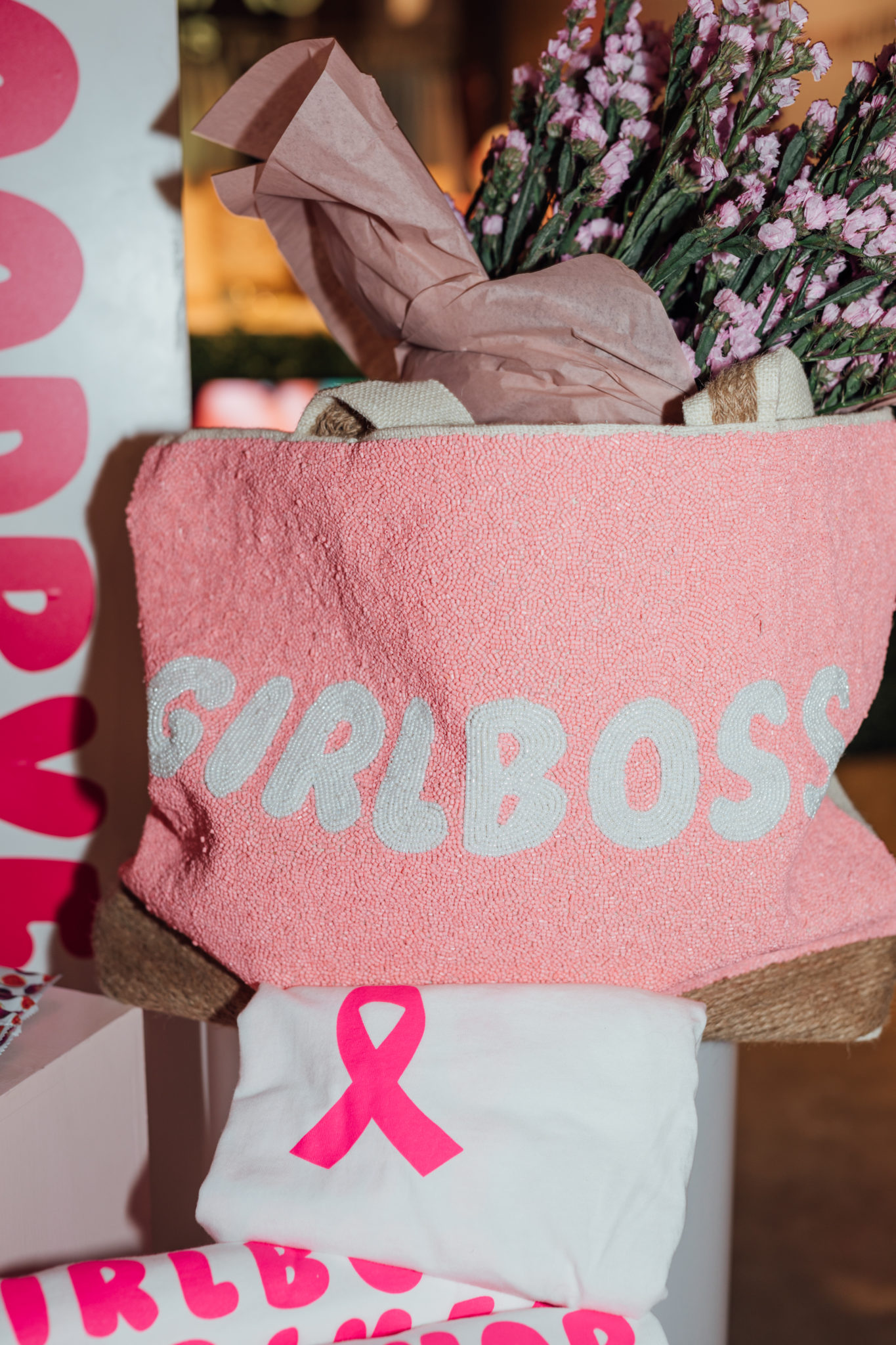 A pink custom clutch bag with the word girlboss printed on it in a white bubblegum font.