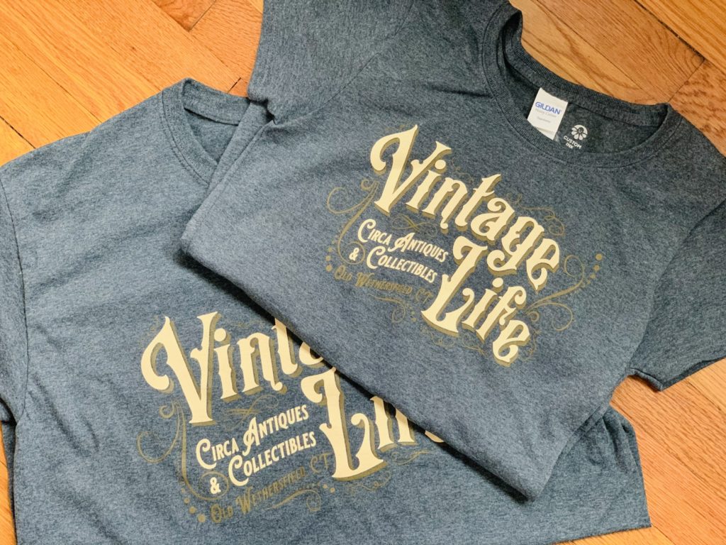 Two gray t-shirts with "Vintage Life" in retro-style text printed on them.