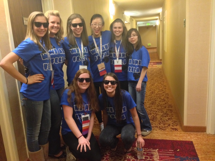 Group of women wearing matching shirts in a hotel hallway