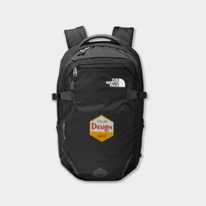 A photo of The North Face Fall Line backpack in black with a red, white, and orange embroidered hexagon on the front that says "Your Design Here." 
