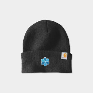 A photo of a black Carhartt Watch Beanie 2.0 with a blue flower-shaped logo on the fold. 