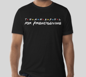 A black t-shirt with text that reads "Thankful for Friendsgiving" in the style of the "Friends" sitcom logo. 