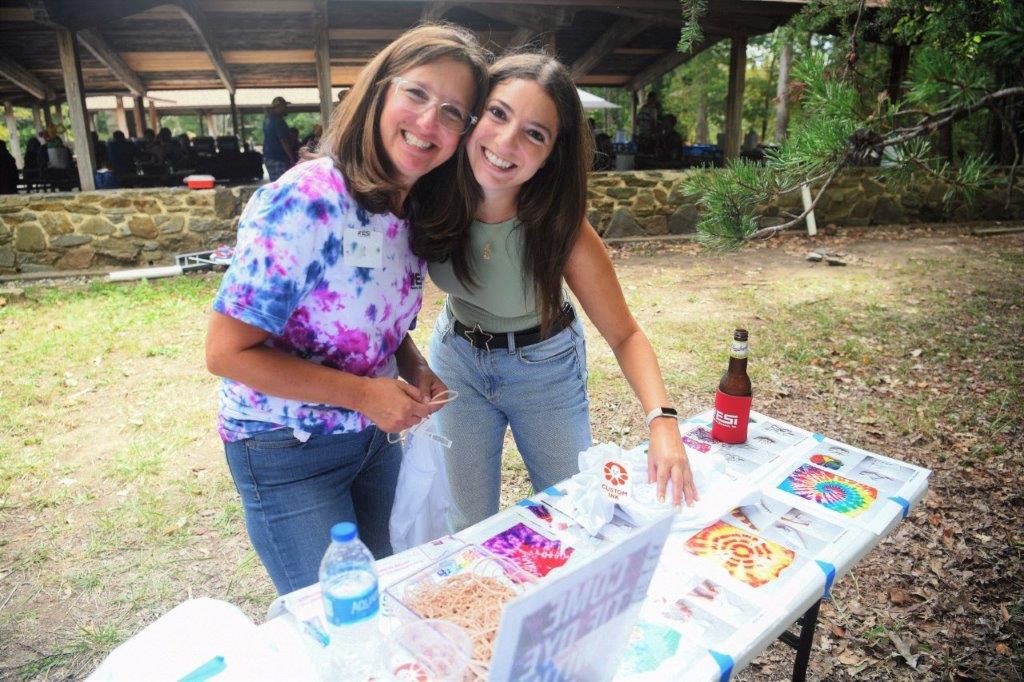 Two women smiling at one of the tie-dye stations at the ESi picnic