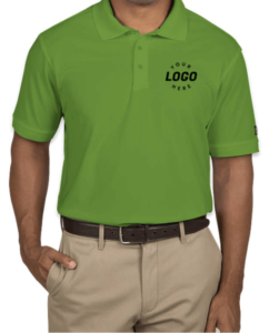 A person wearing a Gridiron Green Ogio Performance Polo tucked into khaki pants. "Your Logo Here" is printed on the left chest area. 
