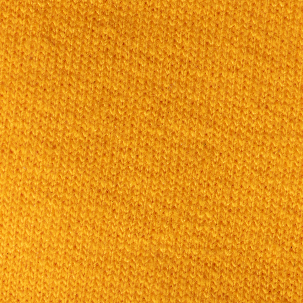 A close-up of golden yellow ringspun cotton to show the close-knit stitching. 