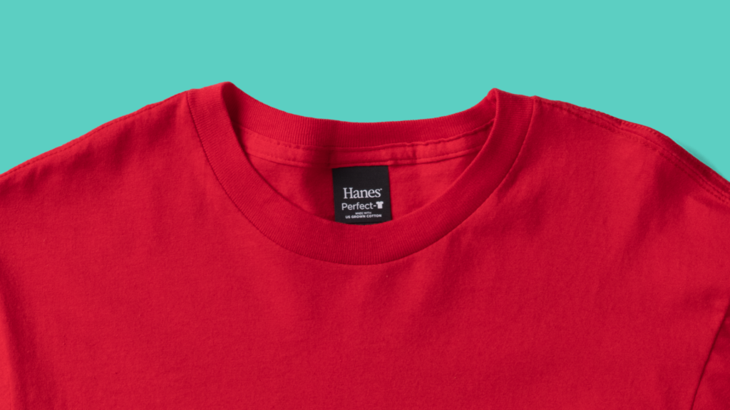 A closeup of the top of a red 100% cotton Hanes t-shirt from the shoulders up. 