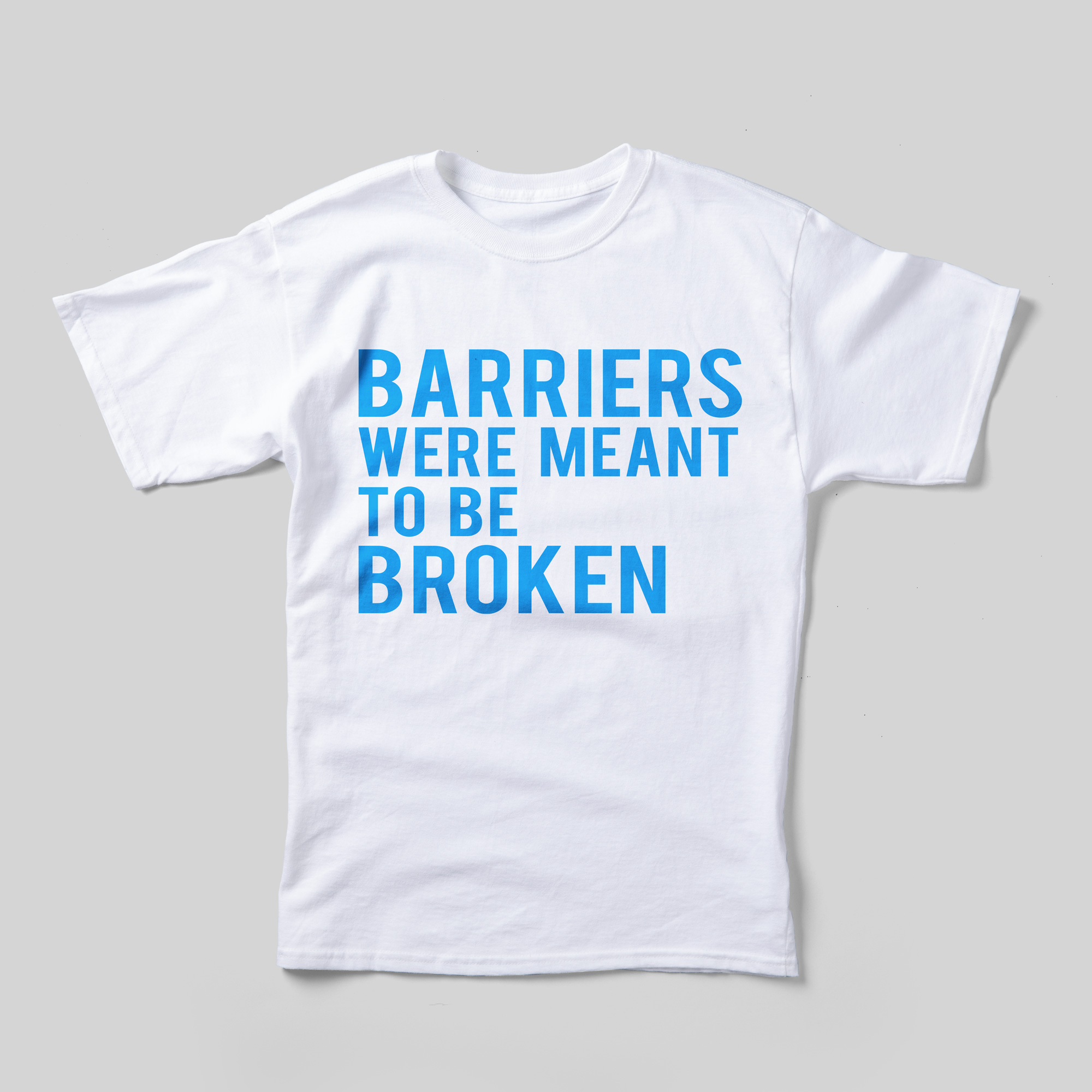 A white t-shirt that reads "Barriers were meant to be broken" in sky blue text.