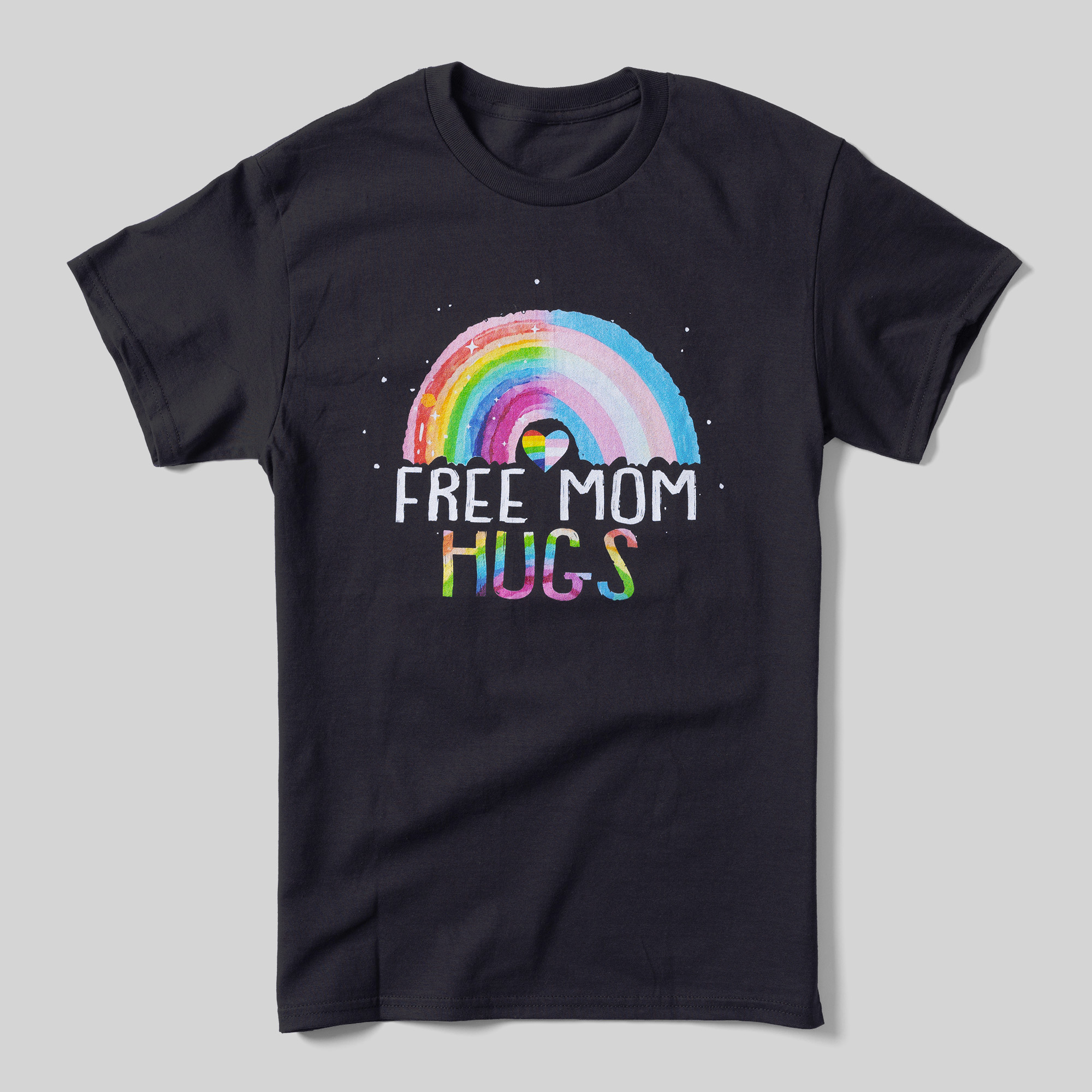 A black t-shirt that reads "Free Mom Hugs" with a rainbow above it in the style of a child's drawing. Half of the rainbow contains the Pride Flag colors, and the other half contains the Trans Pride Flag colors.