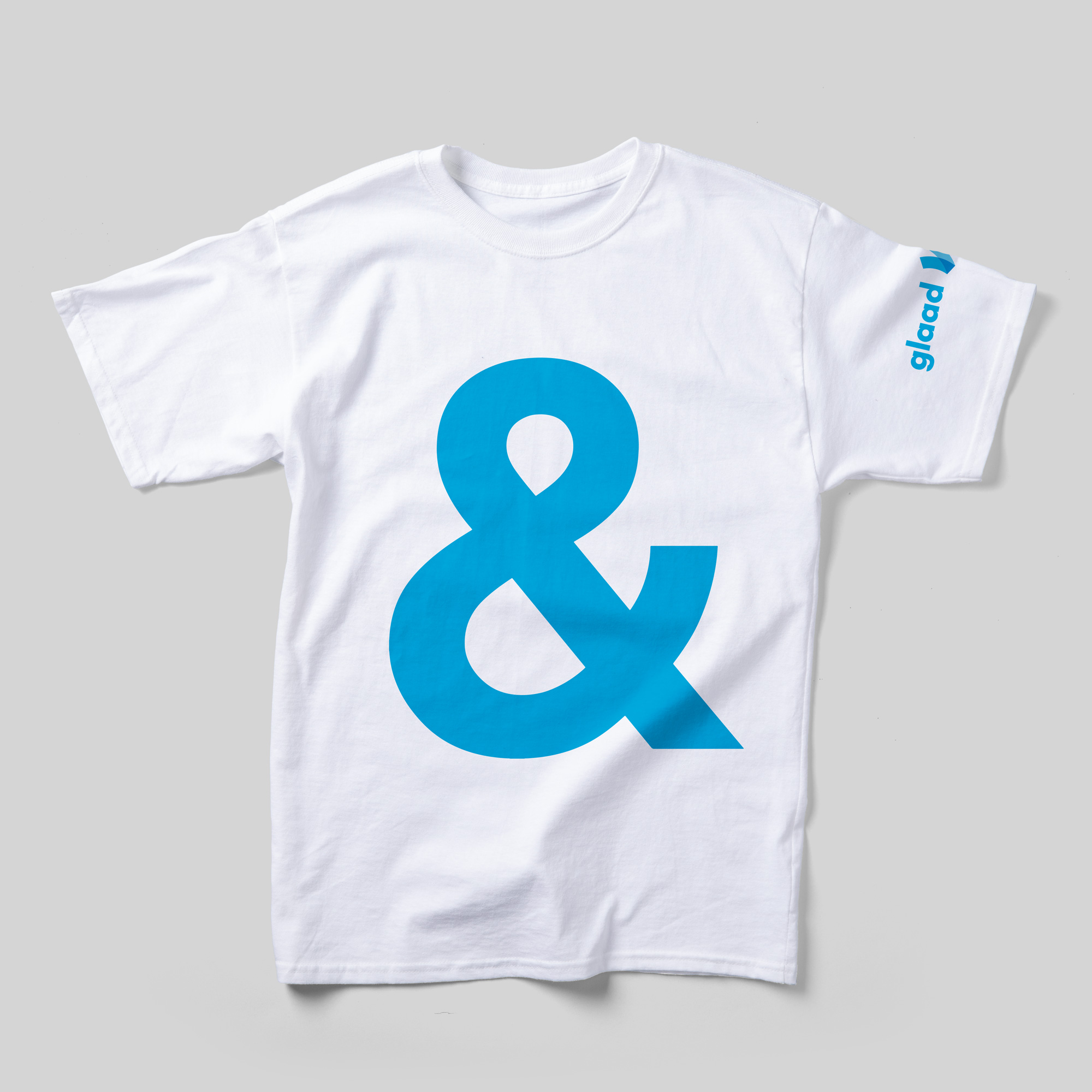 A white t-shirt with a large sky blue ampersand in the center. The GLAAD logo is printed on the sleeve.