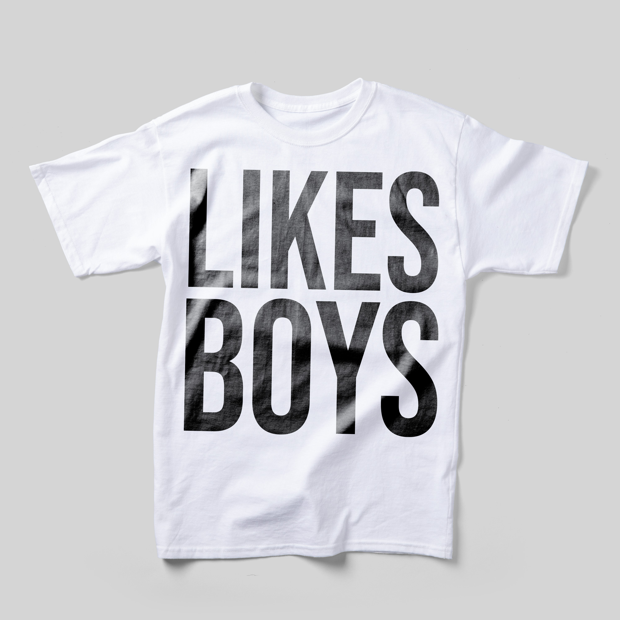 A white t-shirt that reads "Likes Boys" in large black text that takes up the entire front.