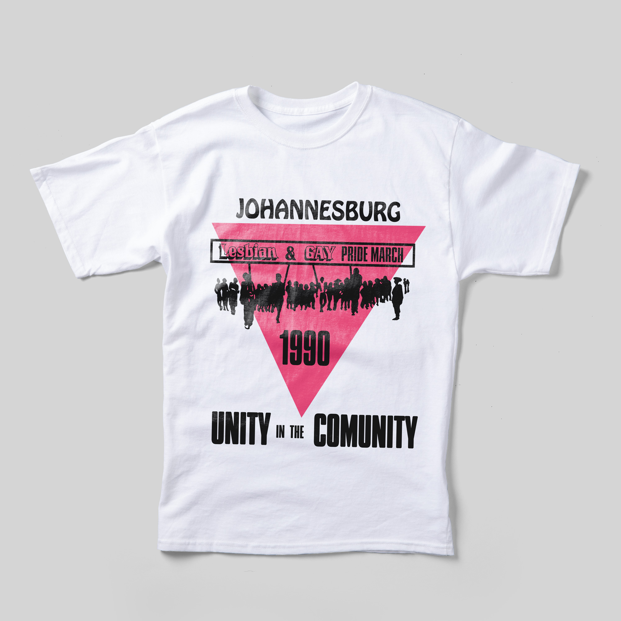 A white t-shirt that reads "Johannesburg Lesbian & Gay Pride March 1990" in black text superimposed over an upside-down pink triangle and a black illustration of marchers. Beneath the image, it reads "Unity in the Community."