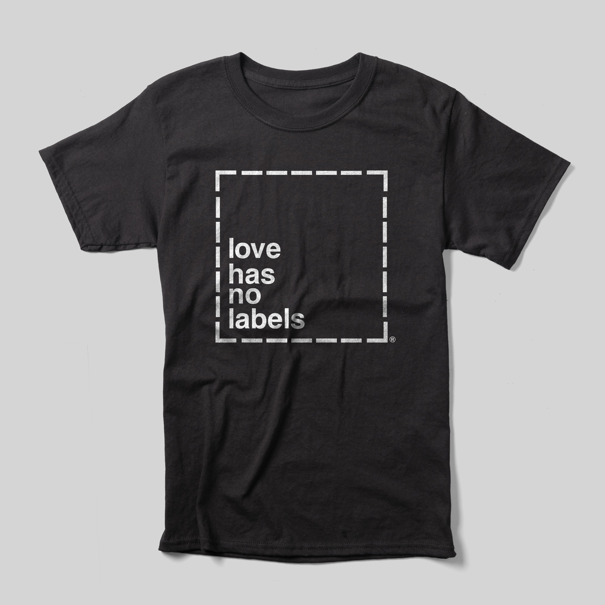A black t-shirt that reads Love Has No Labels inside of a white dotted line box.