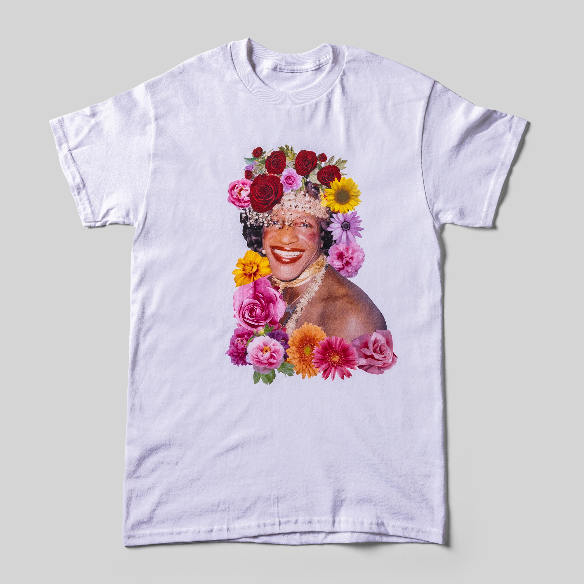 A white t-shirt with a color photo of Marsha P. Johnson and the added flowers around her.