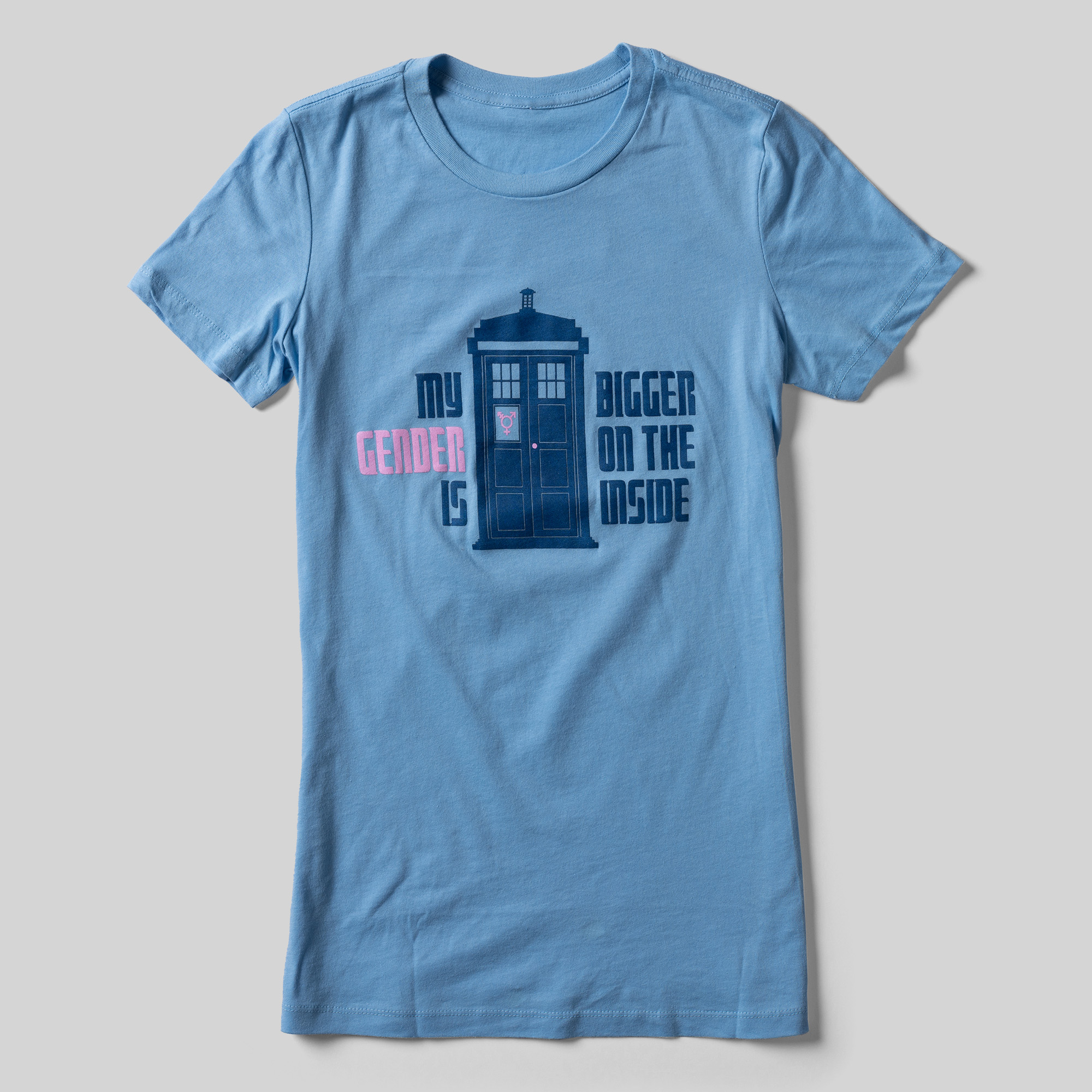 A blue t-shirt with an illustration of the Tardis from Doctor Who that reads "My Gender is Bigger on the Inside."