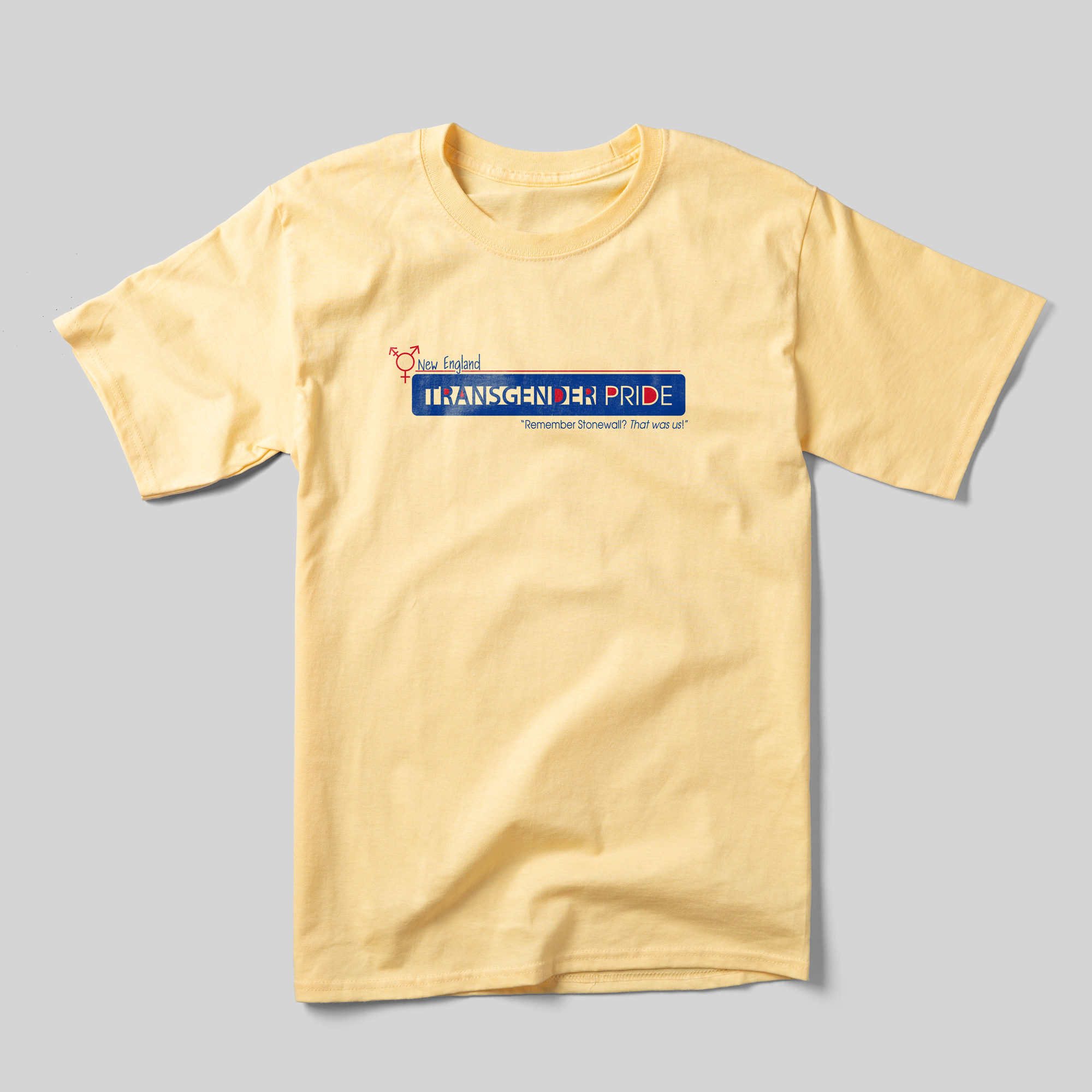 A yellow t-shirt that reads "New England Transgender Pride" with "'Remember Stonewall? That was us!'" beneath it. The text is in deep blue and red.