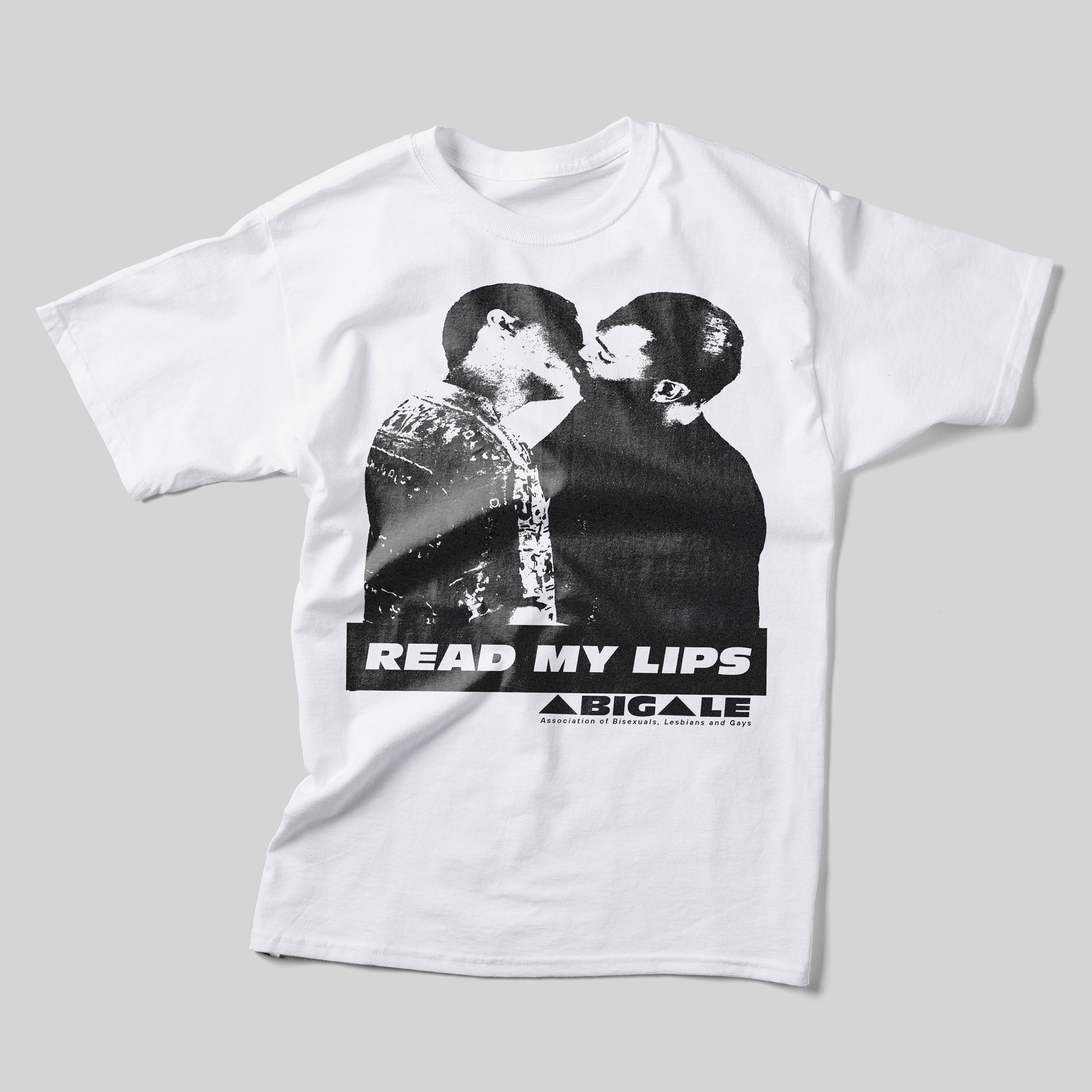 A white t-shirt with a photo of two men kissing in black and white. Beneath the photo, it reads "Read My Lips" and the logo for "ABIGALE: Association of Bisexuals, Lesbians, and Gays."