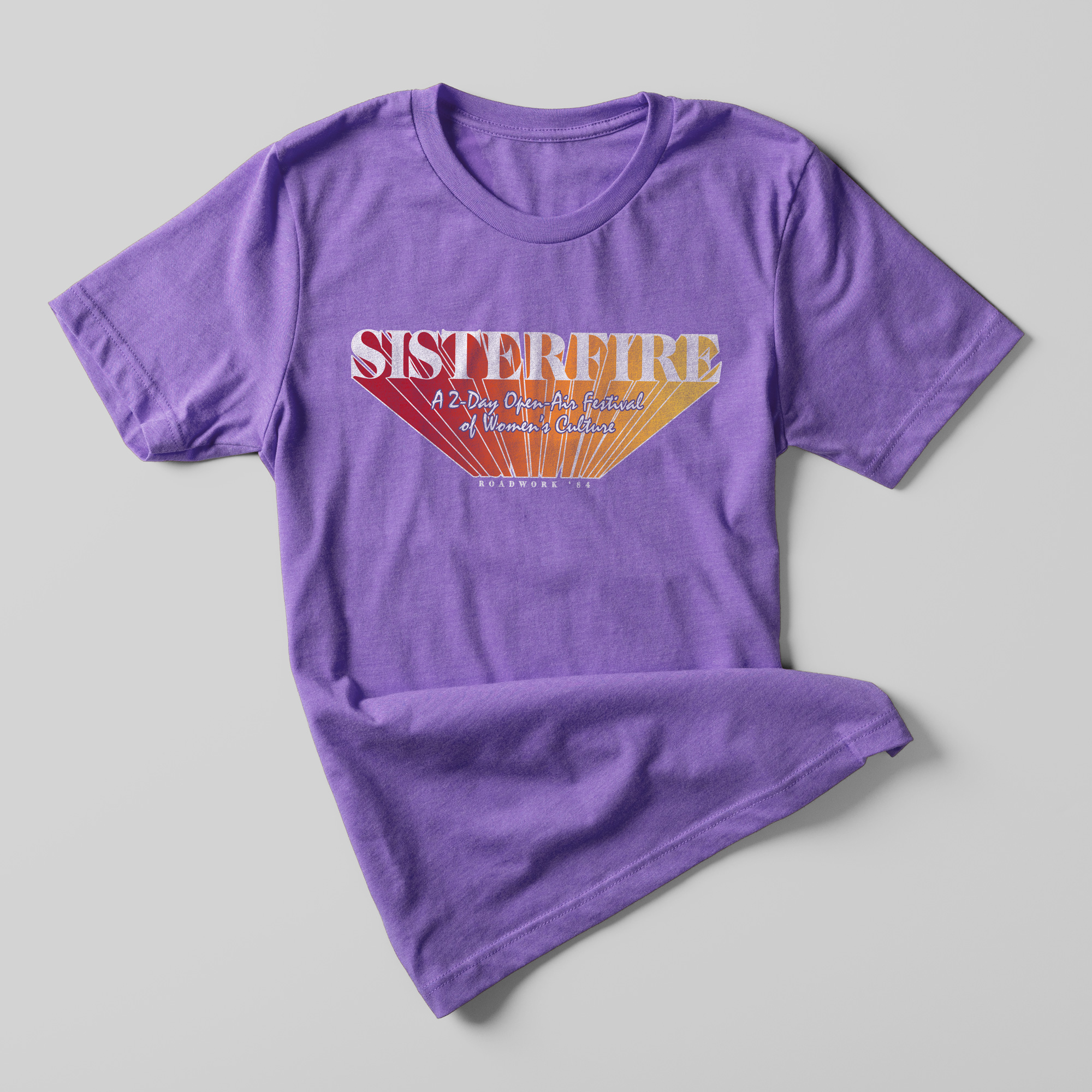 A purple t-shirt that reads "Sisterfire A 2-day Open Air Festival of Women's Culture"