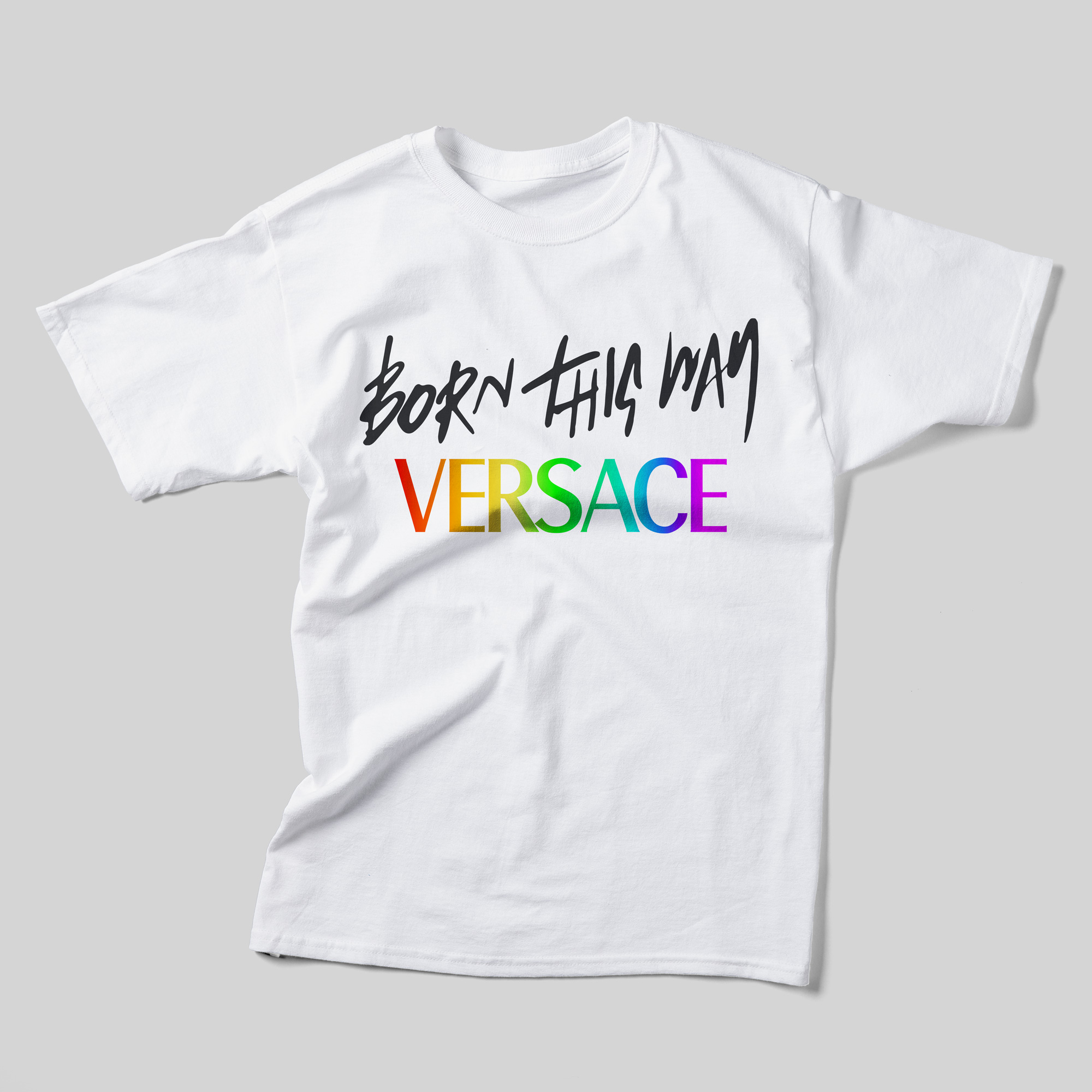 A white t-shirt that says Born This Way Versace. Born This Way is in a black, handwritten font, and Versace is in a rainbow font.