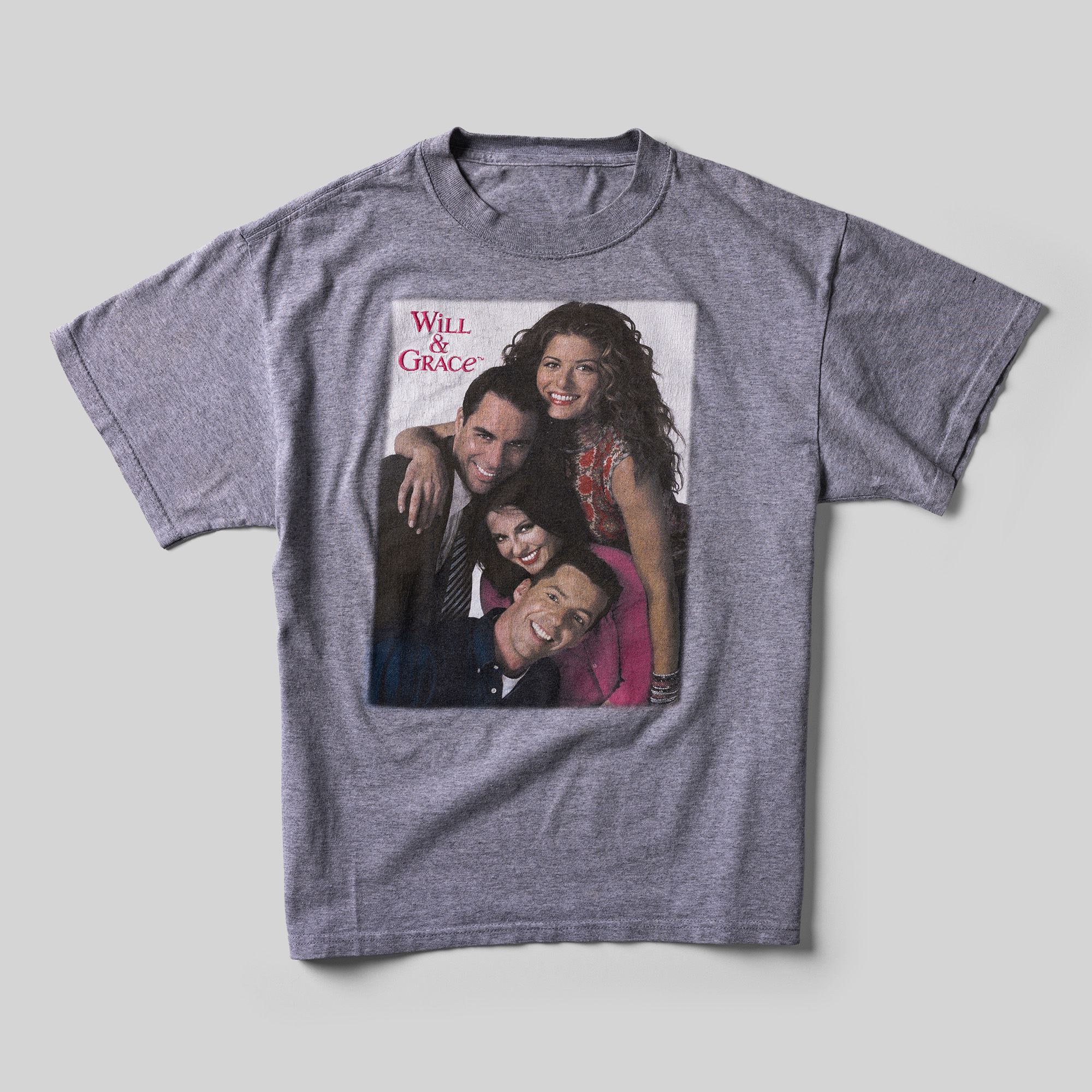 A gray t-shirt with a color photo of the main cast of Will & Grace with "Will & Grace" printed in the corner.