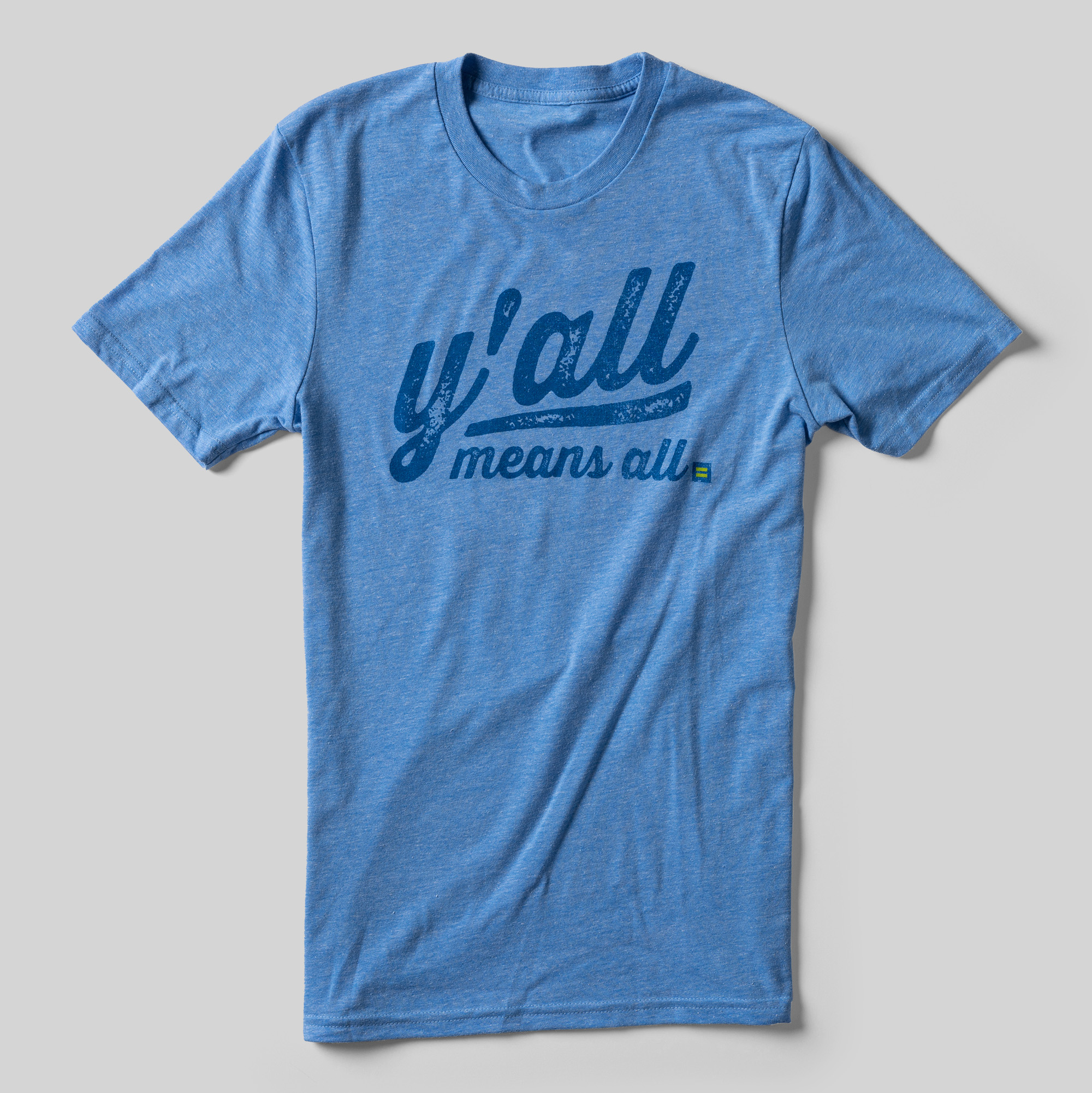 A heather blue t-shirt that reads Y'all means all in dark blue baseball-jersey style lettering.