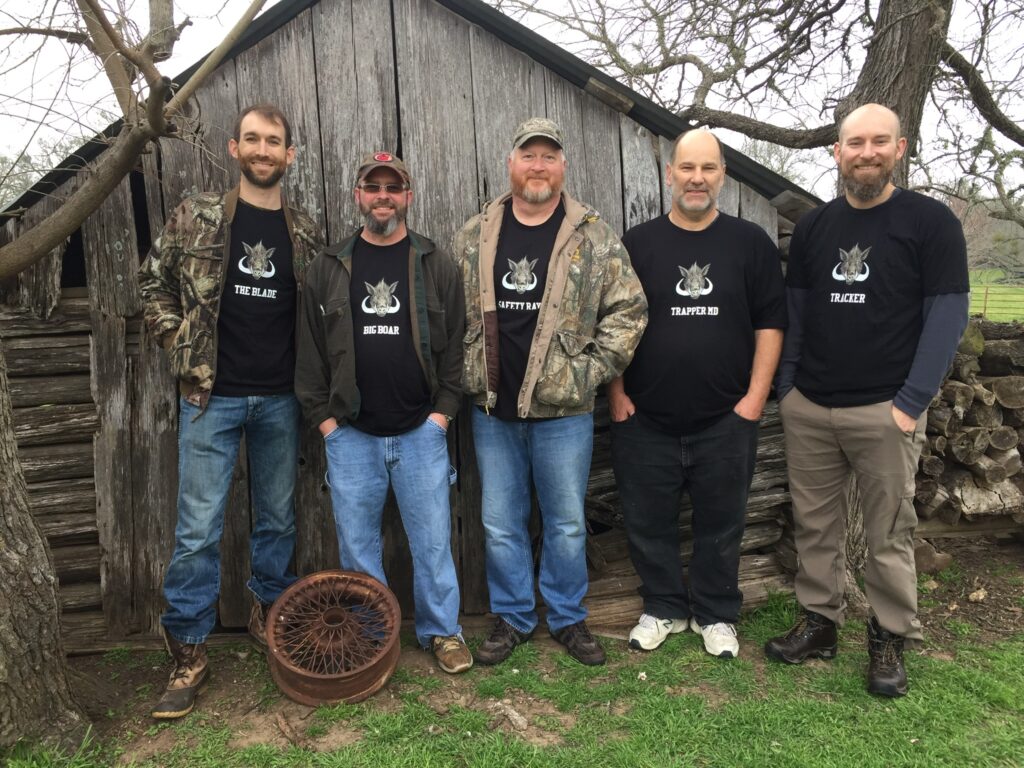 A group of friends on a hunting trip wearing t-shirts personalized with each of their nicknames. 