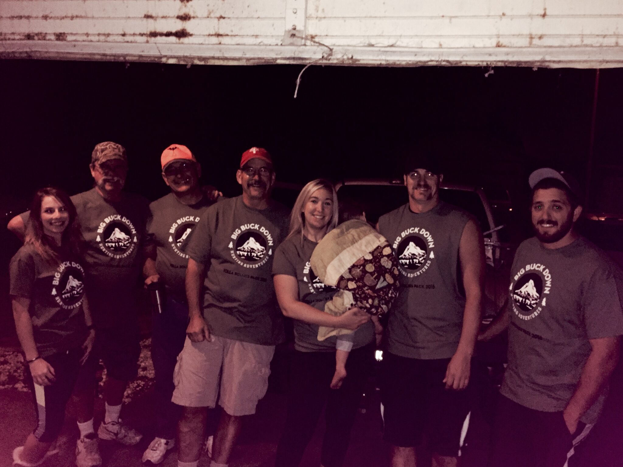 A group of friends and family on a buck hunting trip wearing matching custom t-shirts. 