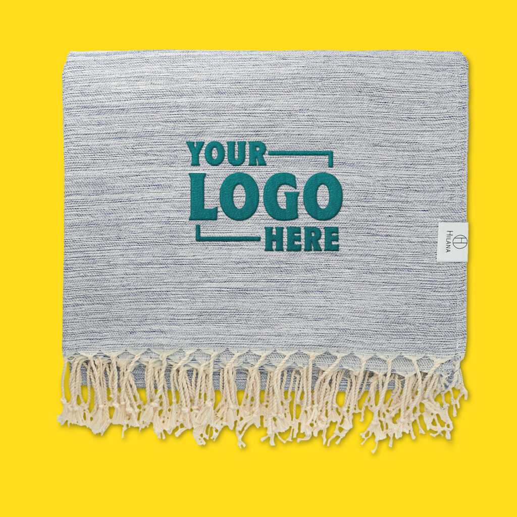 The Halana Turkish Towel with "Your Logo Here" printed on the corner. 