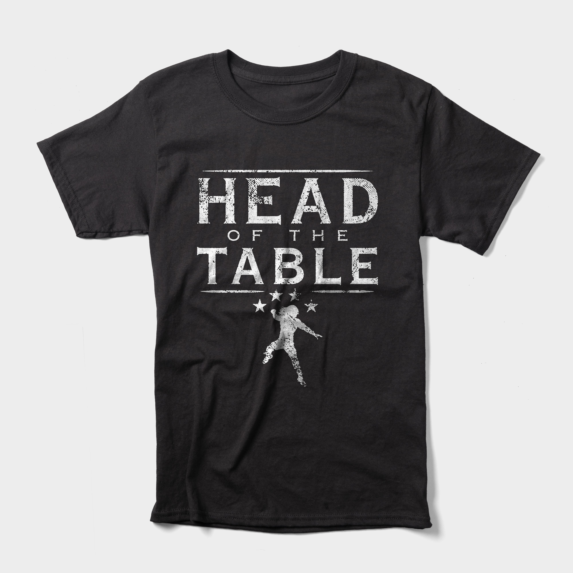 Roman Reigns' t-shirt features bold lettering that reads "Head of the Table" with a white figure performing his signature Superman Punch. 